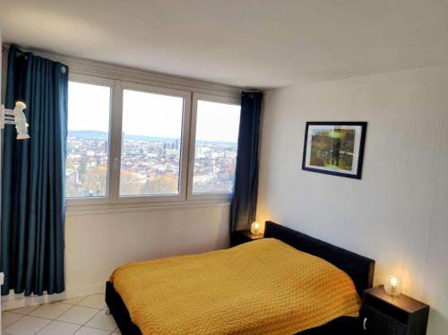 une chambre avec un lit et deux fenêtres dans l'établissement Appart panoramique Nancy, à Nancy