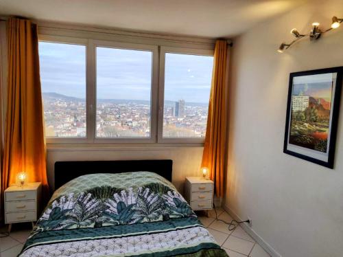 une chambre avec un lit avec vue sur une ville dans l'établissement Appart panoramique Nancy, à Nancy