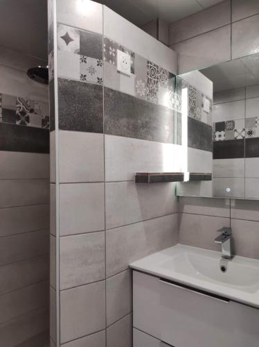 une salle de bain blanche avec un lavabo et un miroir dans l'établissement Appart panoramique Nancy, à Nancy