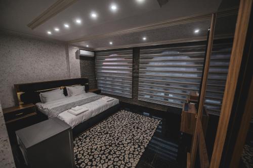um quarto com uma cama e uma grande janela em Hotel Premium em Pristina