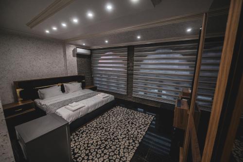 a bedroom with a bed and a large window at Hotel Premium in Pristina