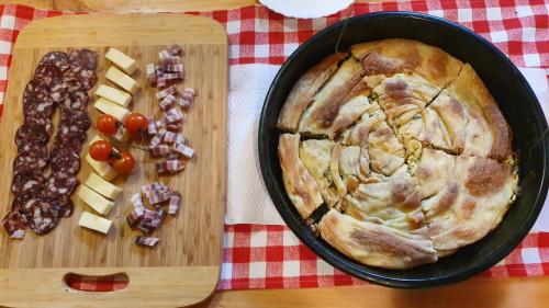 een taart in een pan naast een snijplank met kaas bij Imanje Jelaš in Slunj