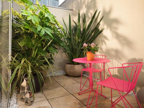 a pink table and two chairs and some plants at St Martins Lane London in London