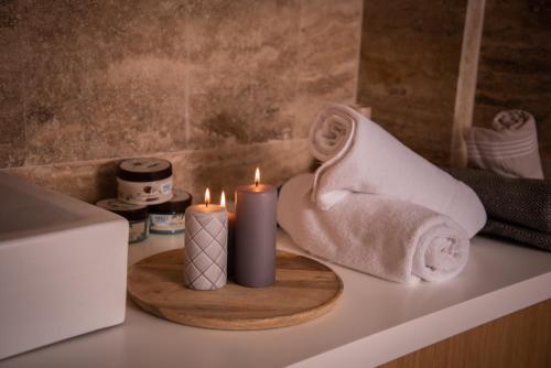 two candles on a bathroom counter with towels at Hotel Borovi Forest Resort & Spa in Sjenica