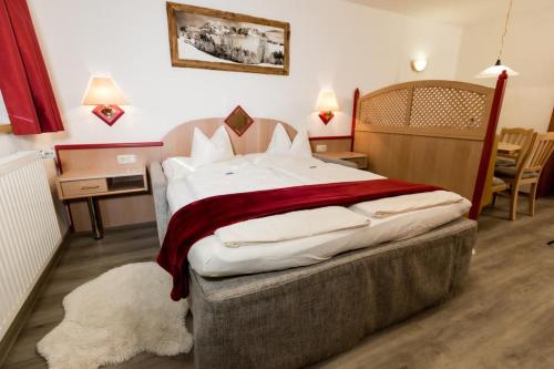 ein Schlafzimmer mit einem großen Bett mit einer roten Decke in der Unterkunft Haus Landmann in Ellmau