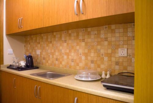 eine Küche mit einer Spüle und einer Arbeitsplatte in der Unterkunft Al-Telal Tower Apartment 2318 in Mekka