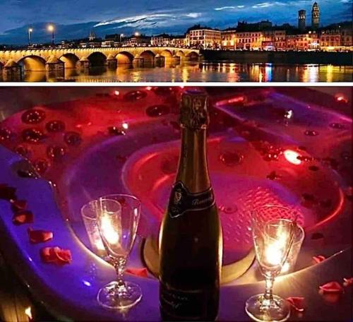 una bottiglia di champagne e due bicchieri di vino su un tavolo di Séjour détente au cœur de MÂCON avec spa et bouteille offerte a Mâcon