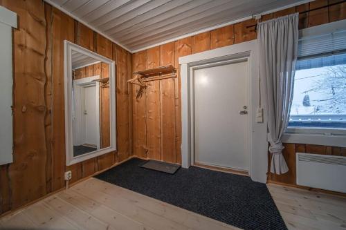 une chambre vide avec une porte et une fenêtre dans l'établissement Levin Nietos, à Kittilä