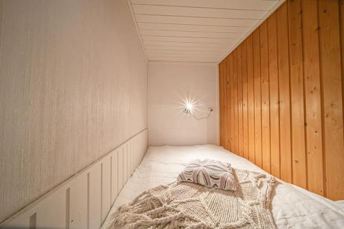 a small room with a bed in a wooden wall at Levi Nietos in Kittilä