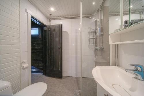 La salle de bains est pourvue d'un lavabo, de toilettes et d'un miroir. dans l'établissement Levin Nietos, à Kittilä