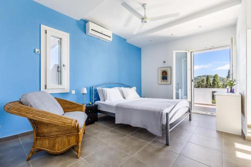 a blue bedroom with a bed and a chair at Villa Pasifika in Loutraki