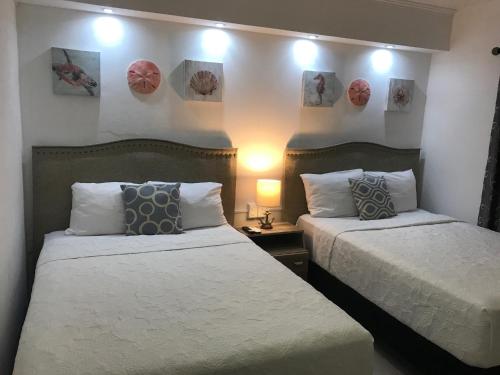 two beds in a hotel room with two beds sidx sidx sidx at Cancun Hotel Zone, Beachfront 2 BR Apartment - Prime Location in Cancún