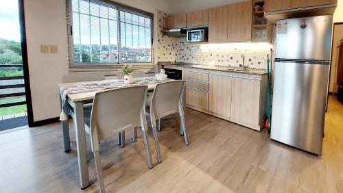 a kitchen with a table and a stainless steel refrigerator at Puertas De La Serena in La Paloma