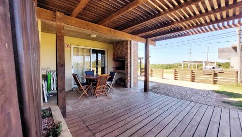 a wooden deck with a table and chairs on it at Puertas De La Serena in La Paloma