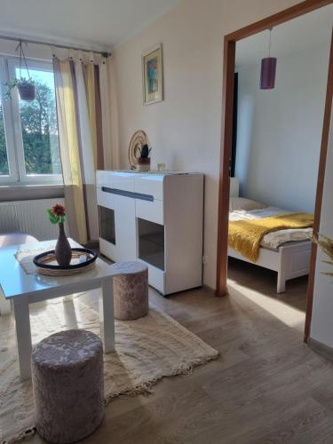 een woonkamer met een tafel en een bed bij Apartament Błysk i Blask in Kłodzko