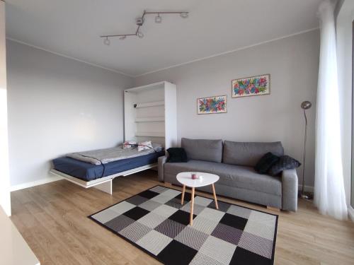 sala de estar con sofá y mesa en Impresja na 17 piętrze en Gdansk