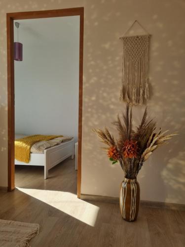 een vaas met bloemen in een kamer met een spiegel bij Apartament Błysk i Blask in Kłodzko