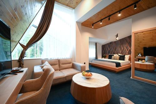 a living room with a couch and a bed at Hotel Borovi Forest Resort & Spa in Sjenica
