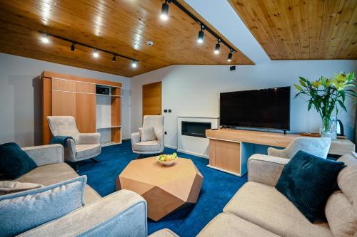 a living room with couches and a flat screen tv at Hotel Borovi Forest Resort & Spa in Sjenica