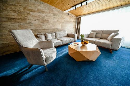 a living room with two chairs and a couch and a table at Hotel Borovi Forest Resort & Spa in Sjenica