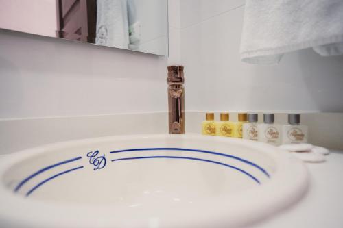 een badkamer met een witte wastafel met blauwe lijnen erop bij Hotel Boutique La Leyenda 1860 in Salamina