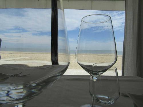 a glass of wine sitting on a table next to a window at B&B Fontanella 32 in Porto SantʼElpidio