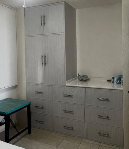 a kitchen with white cabinets and a blue table at Cancun Hotel Zone, Beachfront 2 BR Apartment - Prime Location in Cancún
