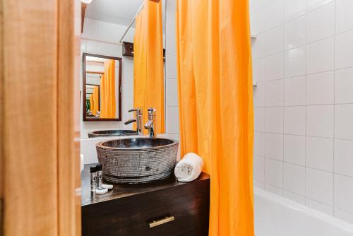 een badkamer met een oranje douchegordijn en een wastafel bij MELLER - Garaje, Wifi, parada esquí bus a 200 mts in Formigal