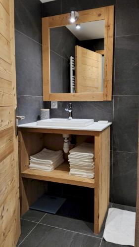 a bathroom with a sink and a mirror at Le Soladret - 2 pièces 4 étoiles - Vue extraordinaire sur les Aravis in La Clusaz