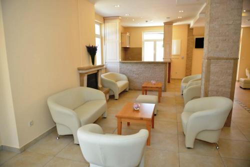 a waiting room with white chairs and a fireplace at Hotel Pax Cordis in Međugorje