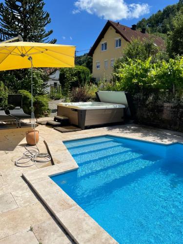 a swimming pool with a yellow umbrella and a swimming pool at Ferienwohnungen Ries in EuÃŸerthal
