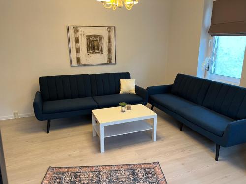 a living room with two blue couches and a coffee table at Lille Vedelsborg in Vejle