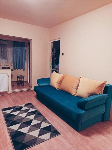 a blue couch in a living room with a checkered floor at Apartament cu o cameră in Cluj-Napoca