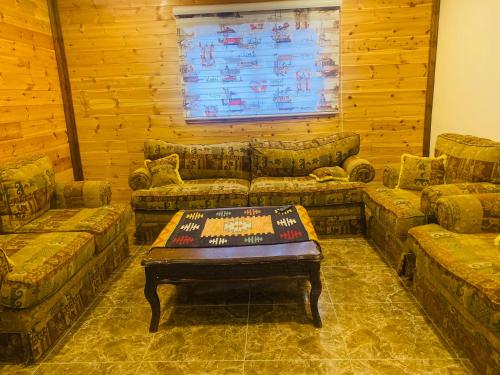 a living room with couches and a table in it at Green houseجوهره الشمال in Ajloun