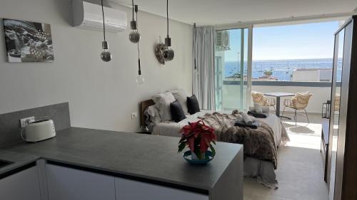 a kitchen and a bedroom with a bed and a balcony at Boutique studio, sea views of Las Vistas and free wifi in Playa de las Americas