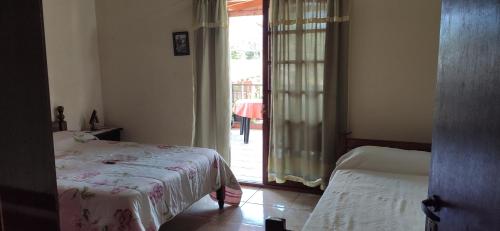 1 dormitorio con 1 cama y puerta corredera de cristal en Cataratas alojamiento en Puerto Iguazú