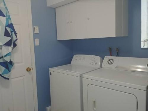 a washing machine in a bathroom with a blue wall at logement,suite l arlequin in Vaudreuil-Dorion