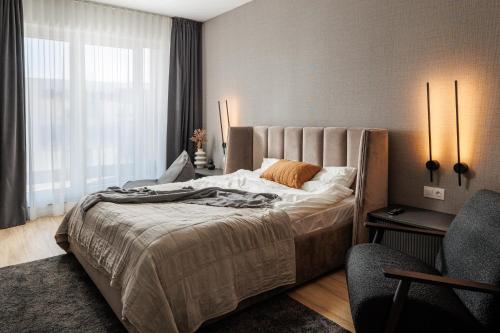 a bedroom with a large bed and a window at Mandala A Designer Penthouse with Free Private Parking, near Mall Coresi in Braşov