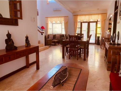 a living room with a table and a dining room at Villa Cantik Kuta Regency in Kuta