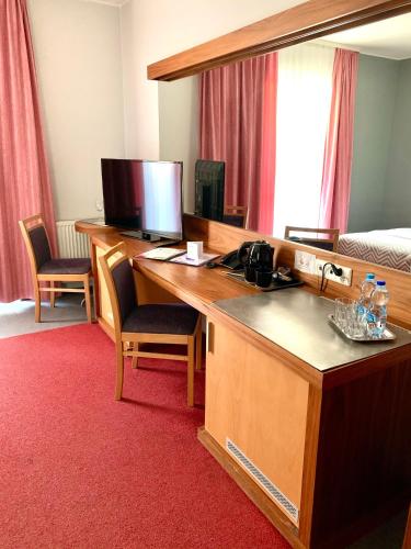 a room with a desk with a computer and a bed at Hotel Szarlota - Kompleksowo na Kaszubach in Kościerzyna
