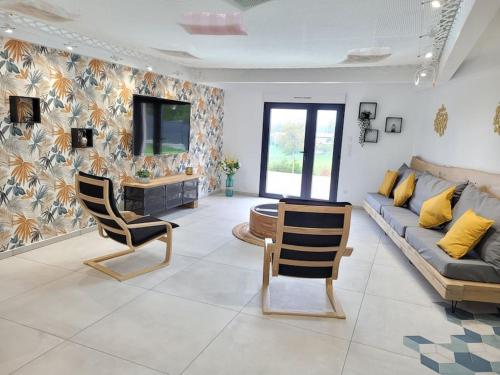 un salon avec un canapé et deux chaises dans l'établissement gîte de l'atelier 15 personnes, à Grazac