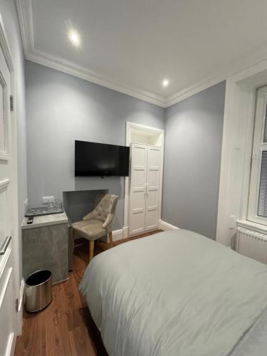 a bedroom with a bed and a desk and a television at Laurieston Inn in Falkirk