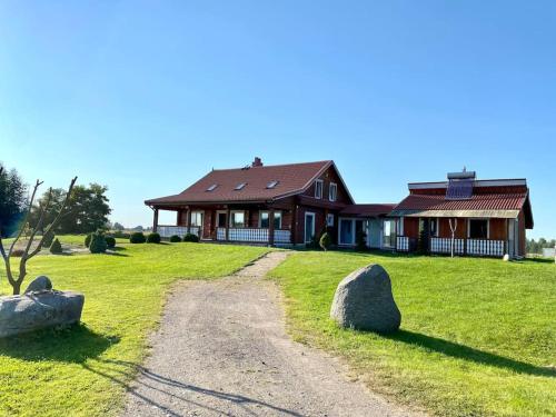 a house on a field with rocks in front of it at Homestead - Ukmergė area 