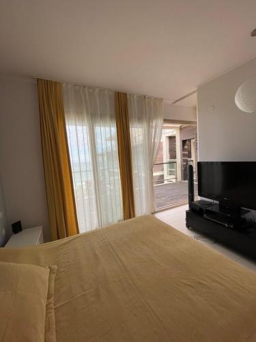 um quarto com uma cama e uma televisão de ecrã plano em YooBulgaria-Obzor SP apartments em Obzor