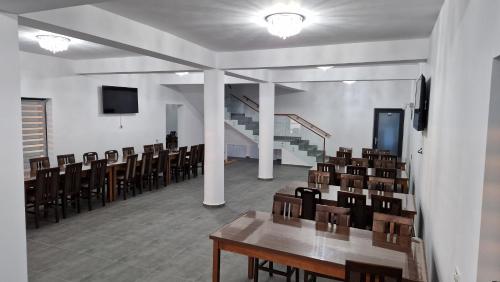a room with chairs and tables and a staircase at Casa de vacanta Larisa in Novaci