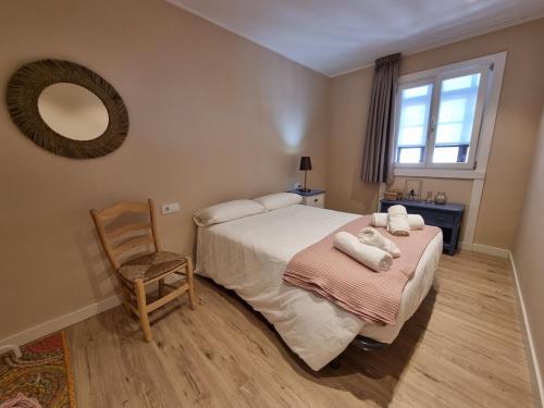 a bedroom with a bed and a chair and a mirror at 15A02 Precioso apto en pleno Puerto de Llanes in Llanes