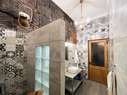 bagno con lavandino e parete in pietra di Aros Apartment a Gyumri