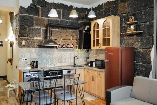 a kitchen with a table and a refrigerator at Aros Apartment in Gyumri