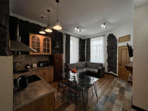 a kitchen and living room with a table and a couch at Aros Apartment in Gyumri