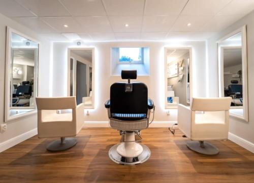 a hair salon with two chairs and a black chair at Villa Brunnby in Mölle